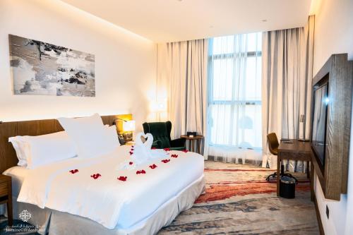 فندق جاسمين جاردن  في جدة: غرفة فندق عليها سرير وورد احمر