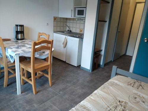 une pièce avec une table et des chaises et une cuisine dans l'établissement Agréable appartement proche Funiculaire, à Bourg-Saint-Maurice