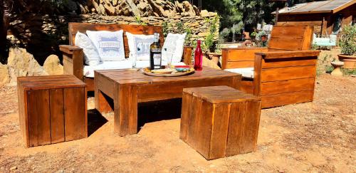 a wooden table and a bed with a bottle of wine at Chambre privée, piscine, pool house, cuisine d'été in La Ciotat