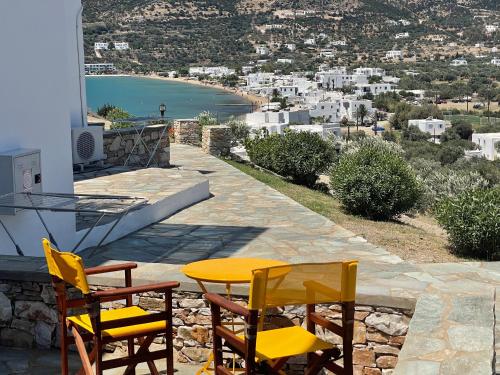 a table and chairs on a patio with a view of a city at Venikouas Hotel in Platis Yialos Sifnos