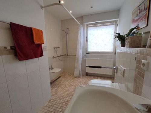 a bathroom with a tub and a toilet and a window at Gästewohnung WaSa in Hamm