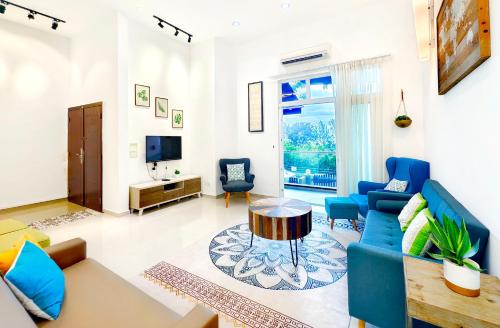 a living room with blue furniture and a tv at Ocean 19 Shamrock Villa Beachfront Big Group 4 Bedroom 5 Bathroom in Tanjung Bungah