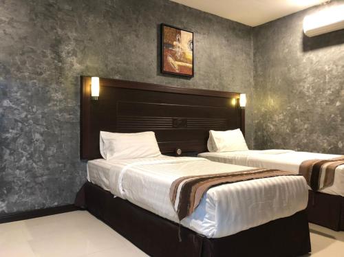 GM Hotel في تشانغلن: سريرين في غرفة الفندق مع سريرين مطلة على السرير