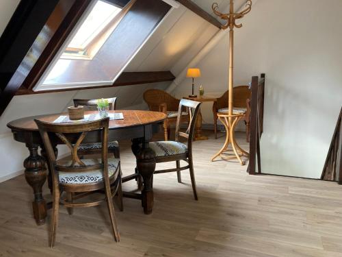 a dining room with a table and chairs and a window at B&B Stations Koffiehuis in Molkwerum
