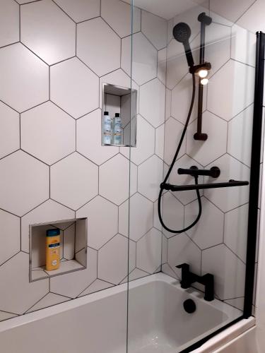 a shower with a glass door and a sink at No's 2 and 5 Llewelyn Apartments in Llanberis