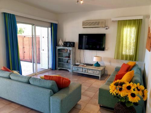 een woonkamer met twee banken en een tv bij Beach Shack in Klorakas