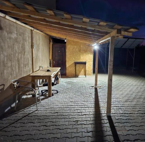 une table en bois dans une pièce vide avec une lumière dans l'établissement Traflor Termhouse, à Vénus