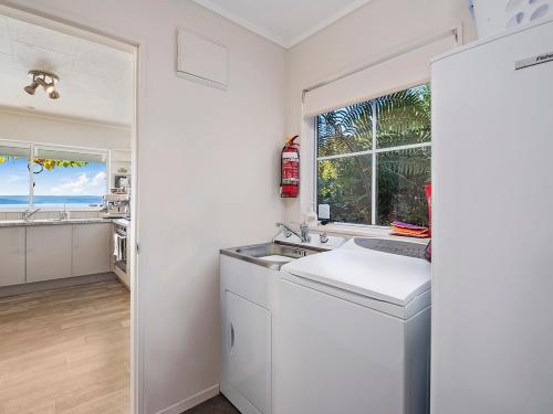 eine weiße Küche mit einem Waschbecken und einem Fenster in der Unterkunft Pukawa Country Lodge - Pukawa Bay Holiday Home in Tokaanu