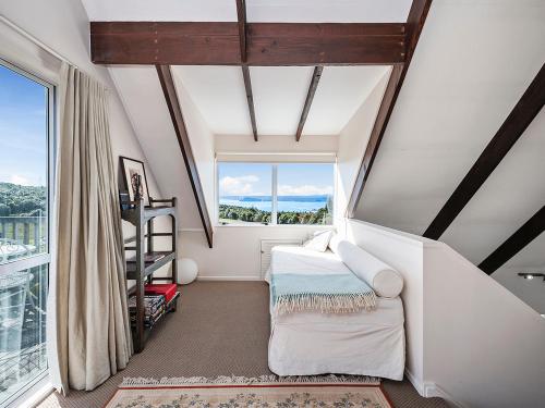 a attic room with a bed and a window at Pukawa Country Lodge - Pukawa Bay Holiday Home in Tokaanu
