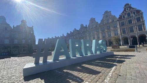 a large sign in front of a large building at "Au pied du Beffroi" - Superbe emplacement in Arras