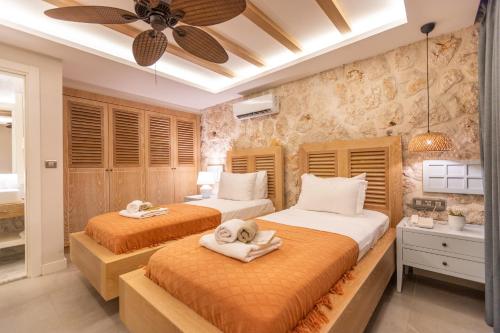 a bedroom with two beds with towels on them at Kalkan Saray Suites Hotel in Kalkan