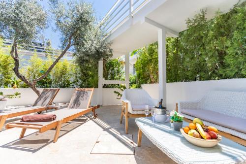 a patio with chairs and a table with a bowl of fruit at Kalkan Saray Suites Hotel in Kalkan