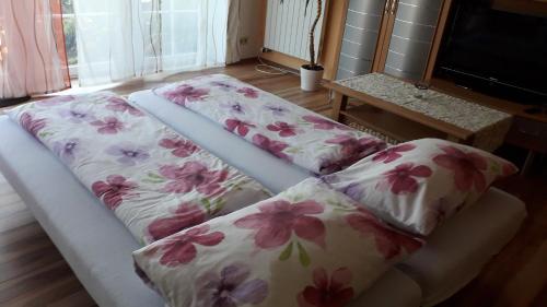 two beds in a living room with flowers on them at Ferienwohnung Am Deich in Bleckede