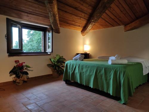 - une chambre avec un lit vert et une fenêtre dans l'établissement Agriturismo Difesa del Monte, à Grisolia