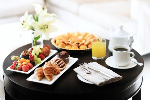 Una mesa negra con alimentos para el desayuno y una taza de café. en Marriott Executive Apartments Riyadh, Convention Center, en Riad
