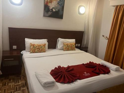a hotel room with two beds with red robes on them at Lux Suites Lantana Road Apartments westlands in Nairobi