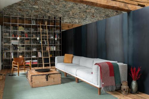 a living room with a couch and a book shelf at Ein Kraftort und architektonisches Juwel in Ardez