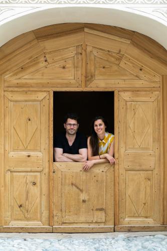 a man and a woman standing in a wooden doorway at Ein Kraftort und architektonisches Juwel in Ardez