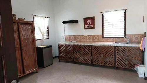 cocina con encimera y fregadero y 2 ventanas en Bonita Oasis Beach Resort, en Moalboal