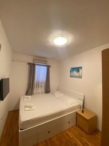 een kleine slaapkamer met een bed en een raam bij Novalja Beach Apartment in Novalja