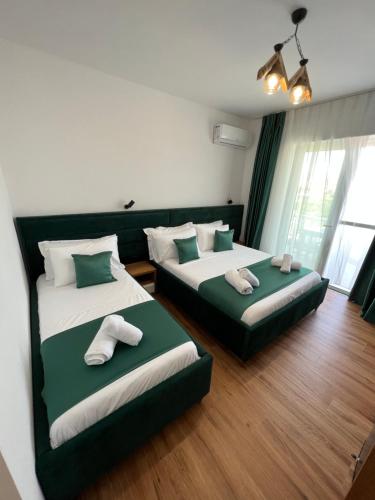 2 łóżka w pokoju zielonym i białym w obiekcie ILLYRIAN hotel w mieście Ksamil