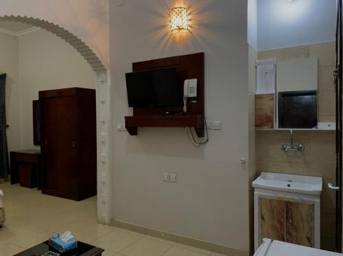 um quarto com uma televisão na parede em رسلين للشقق المخدومة em Hail