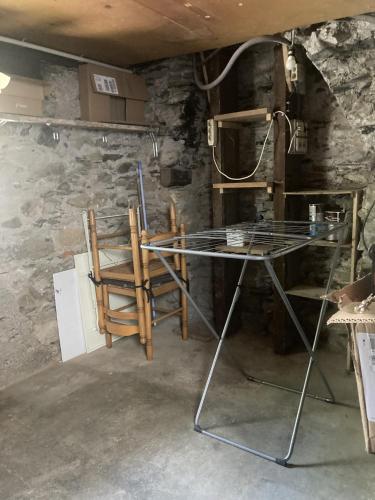 Cette chambre est dotée d'une table, de chaises et d'un mur en pierre. dans l'établissement La « cabaneste » dans Arreau, à Arreau