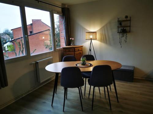 a table and chairs in a room with a window at Joli Appartement Marcq en Baroeul proche Lille in Marcq-en-Baroeul