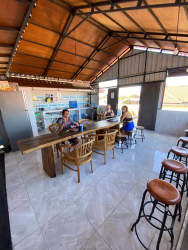 un grupo de personas sentadas en una mesa en una cocina en Amigos Guesthouse & Hostel, en Canggu