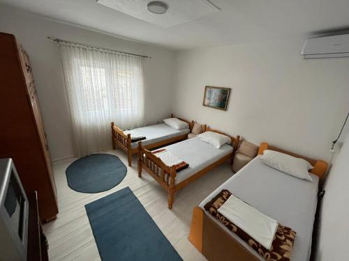 Habitación pequeña con 2 camas y sofá en Smeštaj Pejčić, en Kovanluk