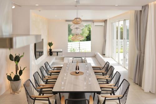 Crystal Villa Bayside في جزيرة مياكو: غرفة طعام مع طاولة وكراسي طويلة