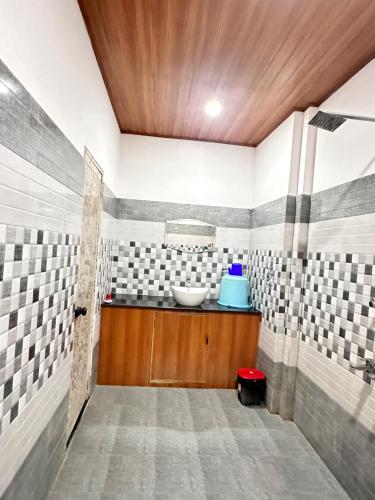 a bathroom with a sink in a room with tiles at Noel's beach homestay in Alleppey