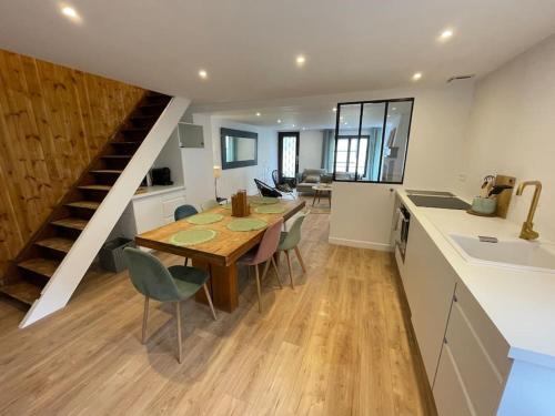 eine Küche und ein Esszimmer mit einem Tisch und einer Treppe in der Unterkunft Maison à Petit Fort Philippe .1mn de la plage in Gravelines