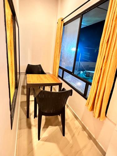 Noel's beach homestay في أليبي: طاولة وكرسي في غرفة مع نافذة