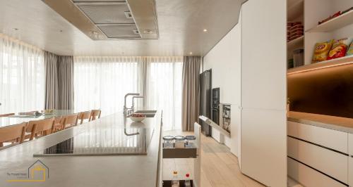 a white kitchen with a counter and a kitchen island at The Present House Da Lat in Khu Chi Lăng