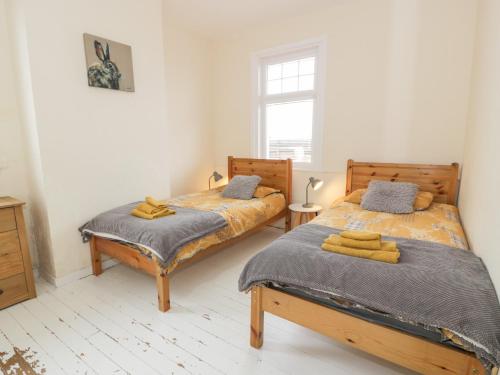 two beds sitting next to each other in a bedroom at The Dairy Cottage in Newton Stewart