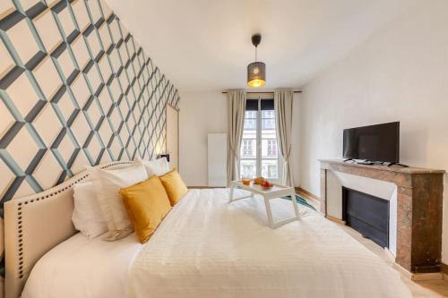 - une chambre avec un grand lit et une cheminée dans l'établissement Le Lumineux 50 m² Gare/château/wifi/Netflix, à Versailles