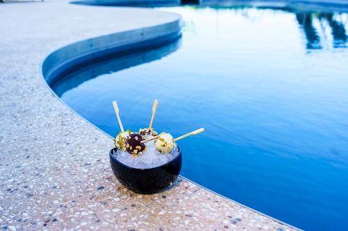 a bowl of food sitting next to a pool of water at Villa Balis Crema Verona Hills in Grezzana