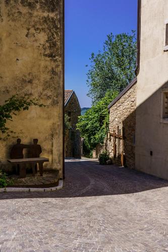two people sitting on a bench in an alley at Villa Balis Crema Verona Hills in Grezzana