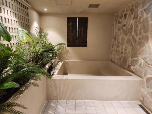 a bath tub in a room with some plants at Banwol Poolvilla in Busan
