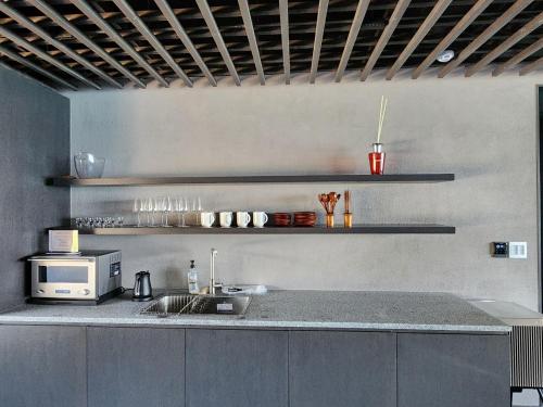 a kitchen with a sink and a microwave at Banwol Poolvilla in Busan