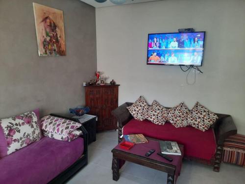 ブズニカにあるAppartement avec piscine à bouznikaのソファとテレビのあるリビングルーム