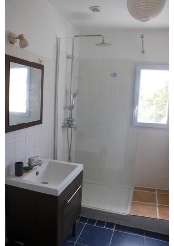 une salle de bain blanche avec un lavabo et une douche dans l'établissement Maison familiale La Baie 10 ps en côte de Jade, à La Bernerie-en-Retz