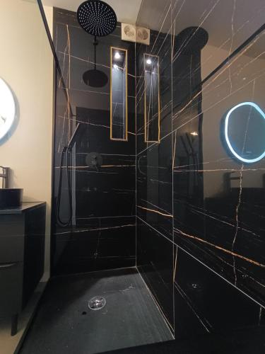La salle de bains noire est pourvue d'une douche et d'un miroir. dans l'établissement Design Therapy, à Lavérune