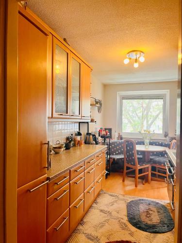 eine Küche mit Holzschränken und ein Esszimmer in der Unterkunft 10 min from U1 - Private room in shared apartment in Wien