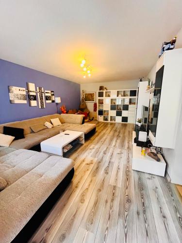 a living room with two couches and a wooden floor at 10 min from U1 - Private room in shared apartment in Vienna