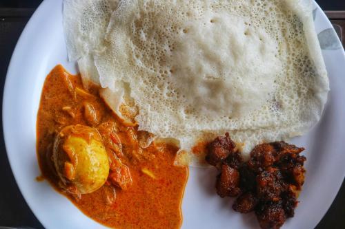 un piatto di cibo con chapati e altri alimenti di Noel's beach homestay a Alleppey