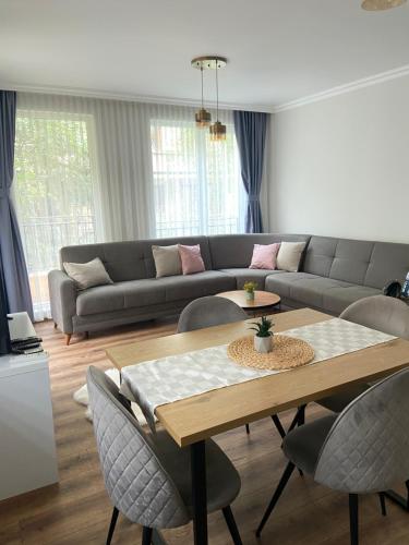 a living room with a couch and a table and chairs at M&M Center Apartment with free parking in Plovdiv