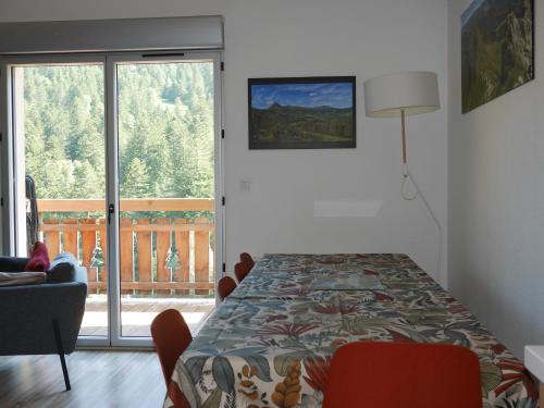LaveissièreにあるRésidence récente au coeur des monts du Cantalのベッドルーム1室(ベッド1台付)が備わります。バルコニーの景色を望めます。