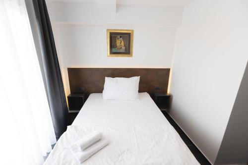 a bedroom with a bed with two white towels on it at D8 B&B in Zadar
